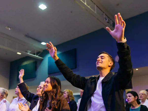 People with arms open worshipping during a service