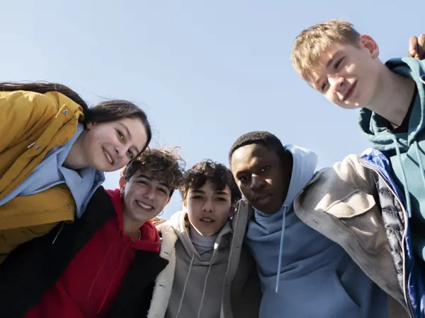 A group of young adults laughing and spending time together outdoors.