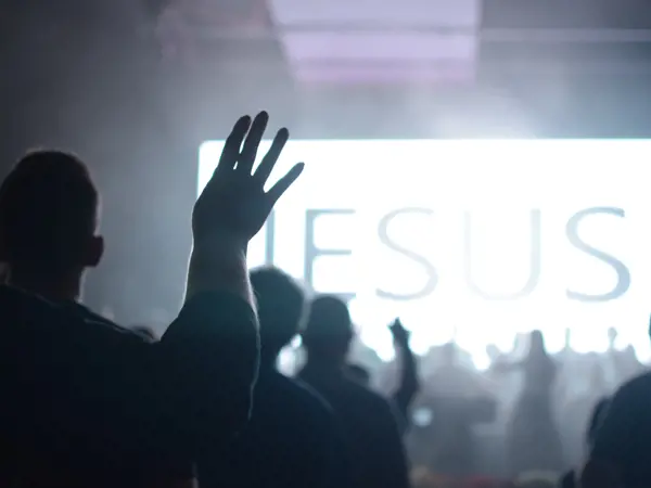 A crowd of people worshipping at church.