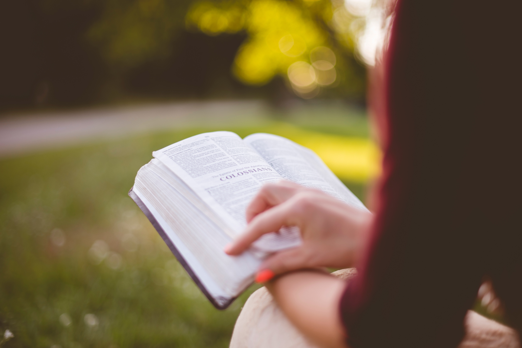 woman reading bible in the park