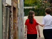 A Salvation Army worker walks through a rough back street with a young woman