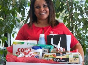 Woman holding a food and material aid hamper