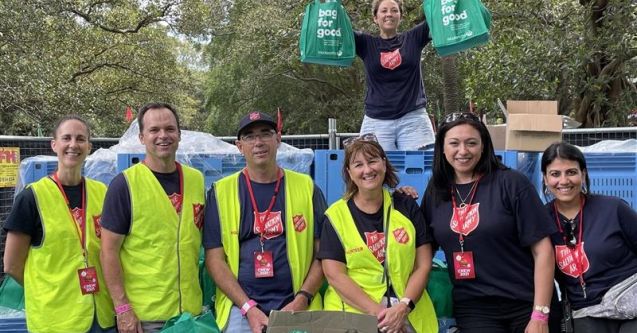 Volunteer Jason (centre, in hat) with a Salvos team packing and selling candle bags to support people who are struggling.