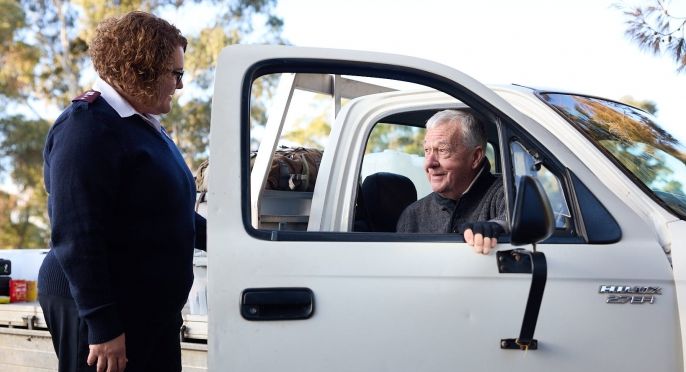 A Salvo officer and a gentleman in a ute
