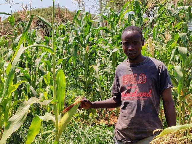 Joseph at his farm where he has been able to produce food for his family. He has planted variety of crops including maize, beans and sweet potatoes.