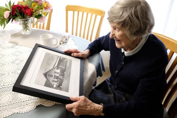 Norma looking at a photo of where she was stationed