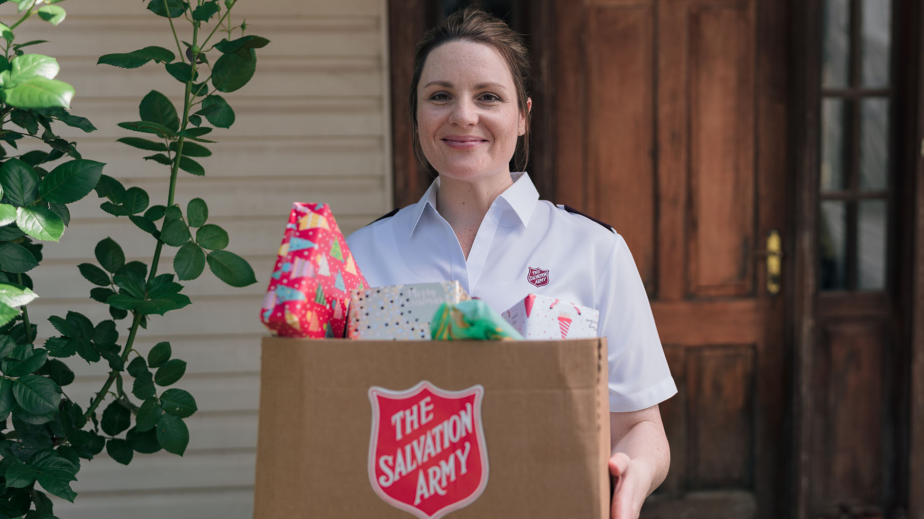 Salvos officer holding Christmas gifts